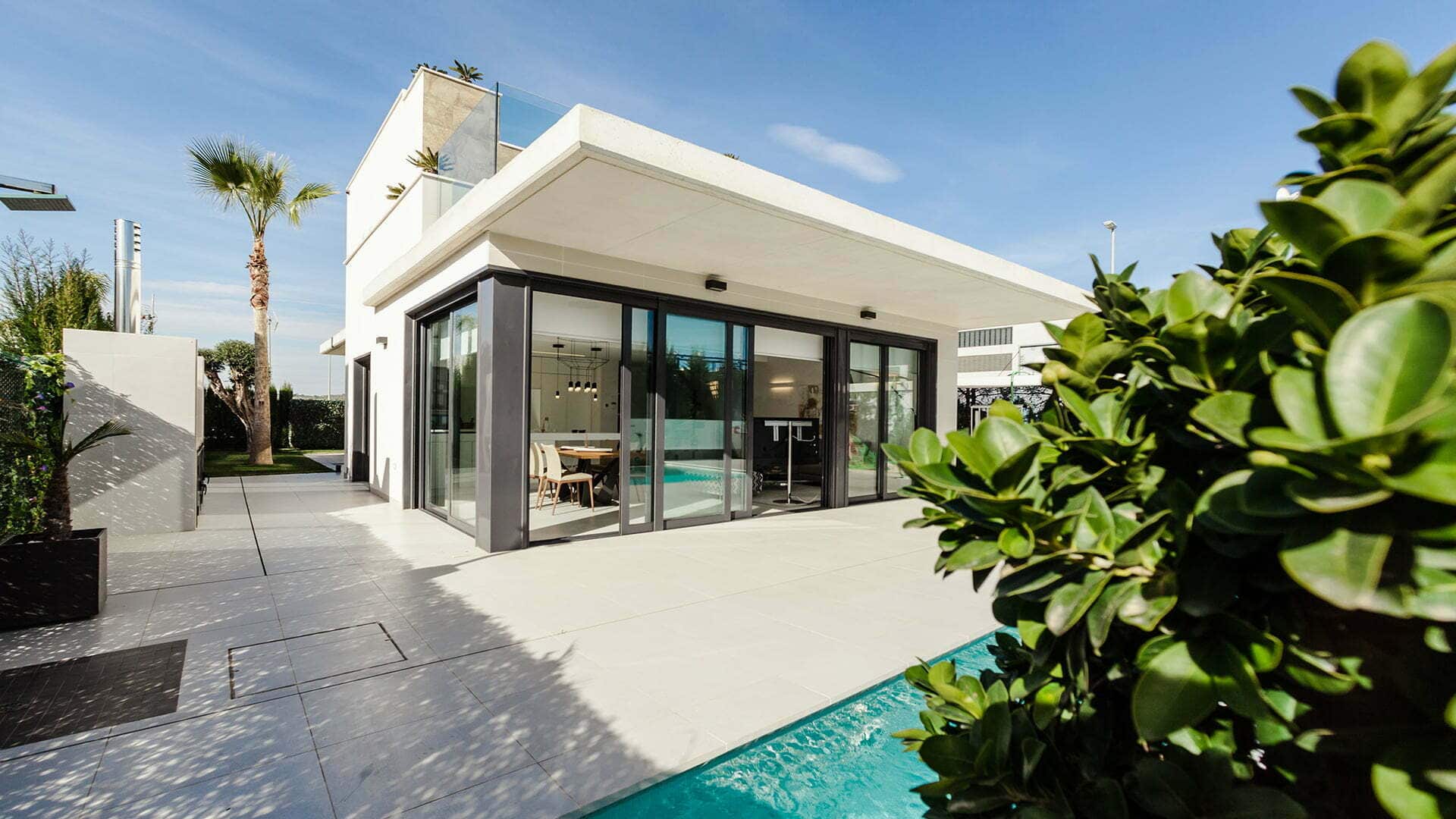 Modern property with a pool and a stunning view. The open concept design features a large living area, kitchen, and floor-to-ceiling windows. Perfect for those seeking a luxurious lifestyle.