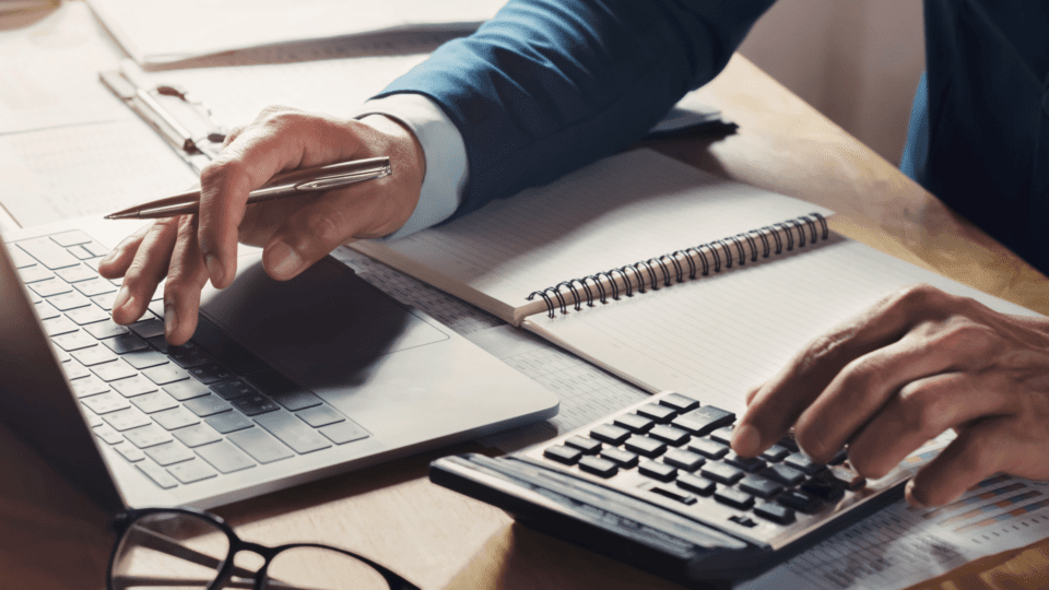 businessman workig using calculator with laptop desk min
