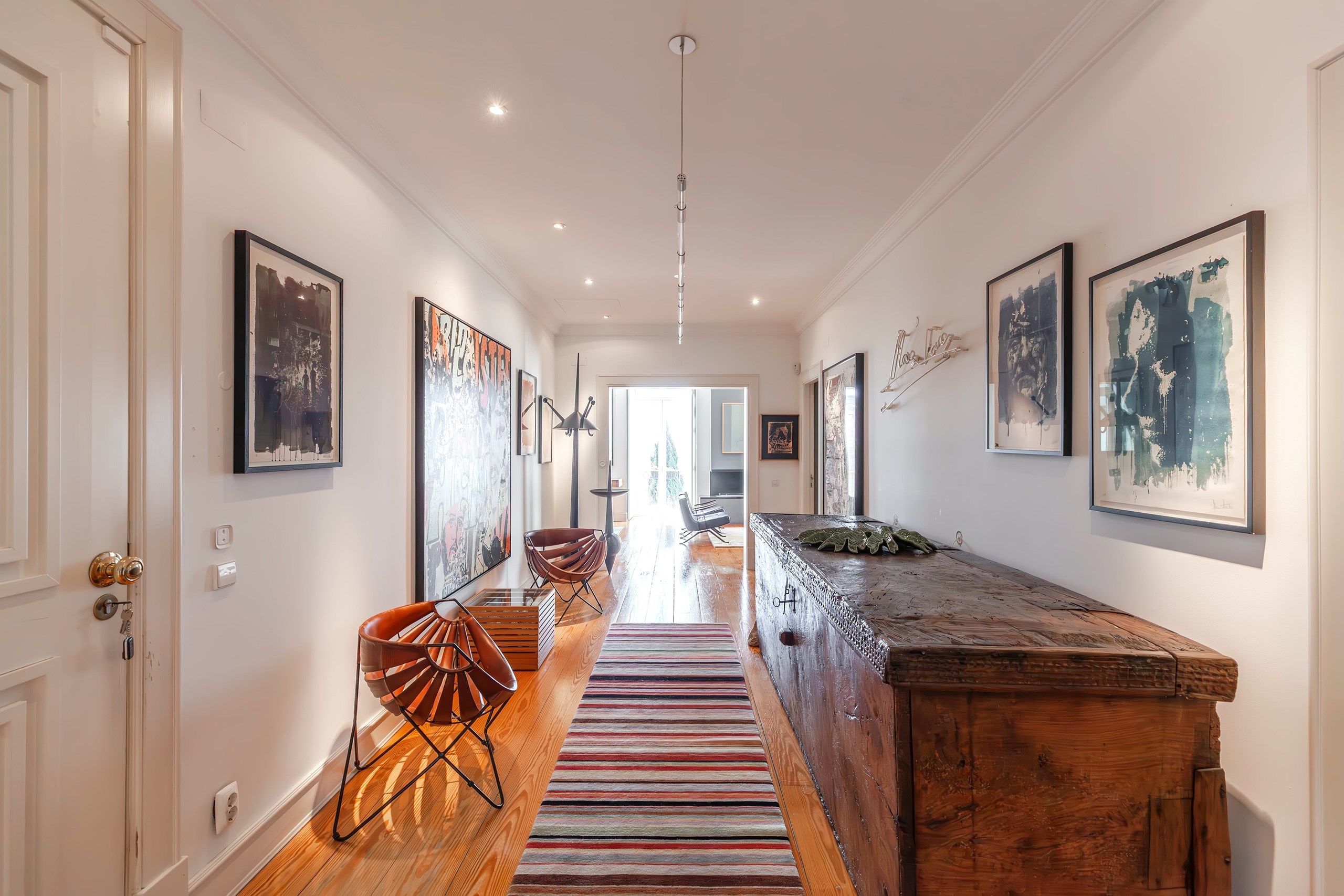 Stylish hallway with artwork and wooden chest