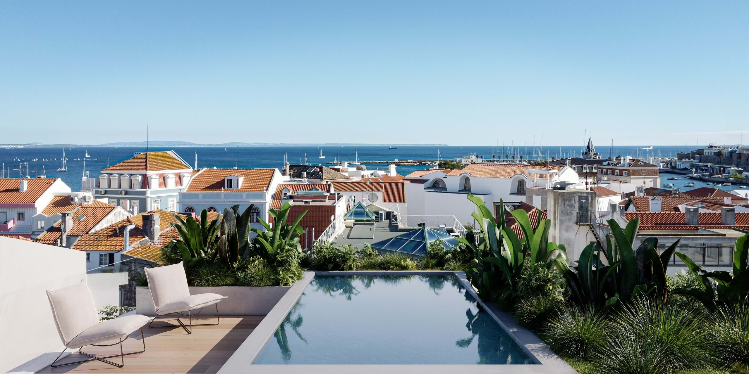Rooftop pool overlooking coastal town and sea