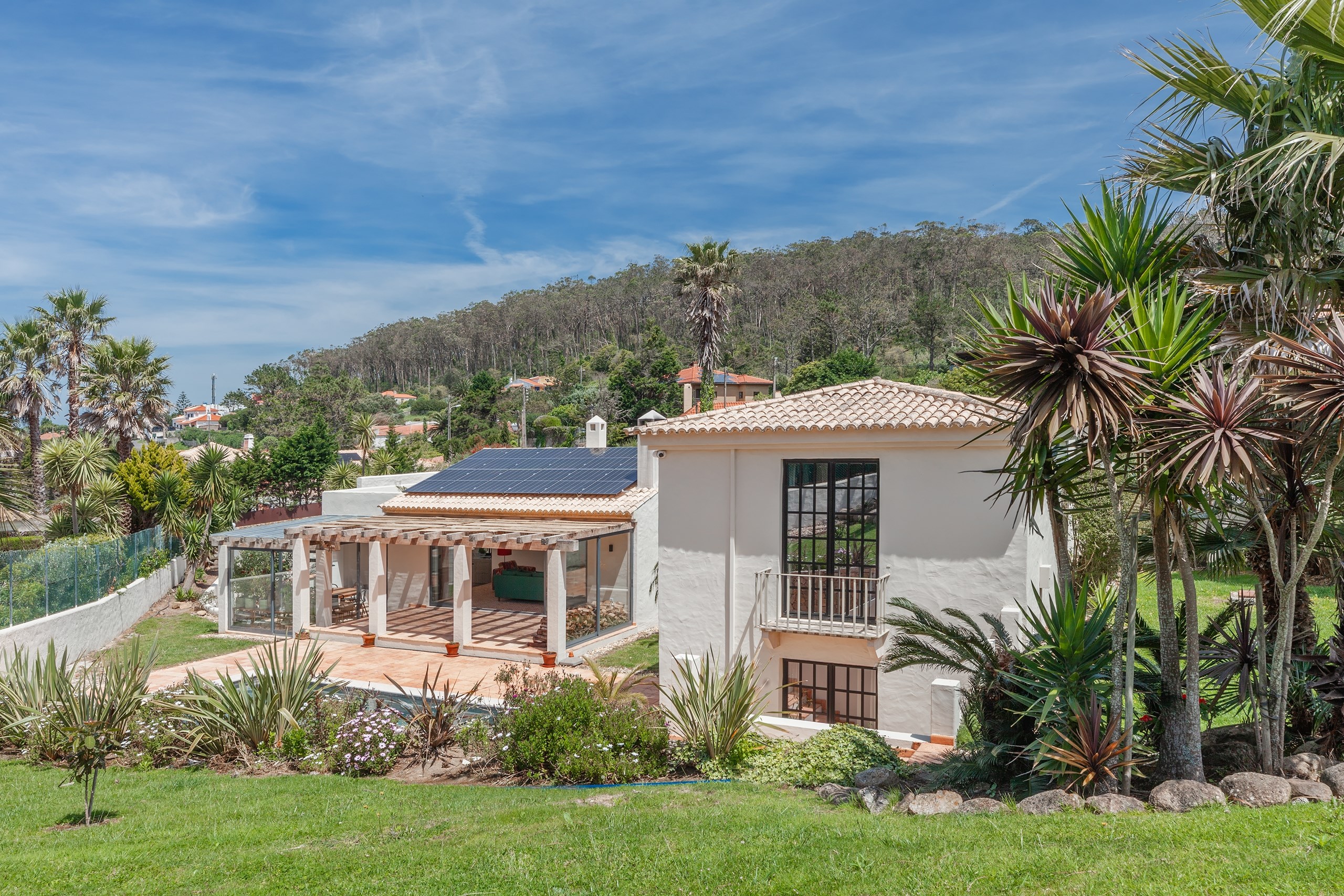 Mediterranean villa with solar panels and lush garden