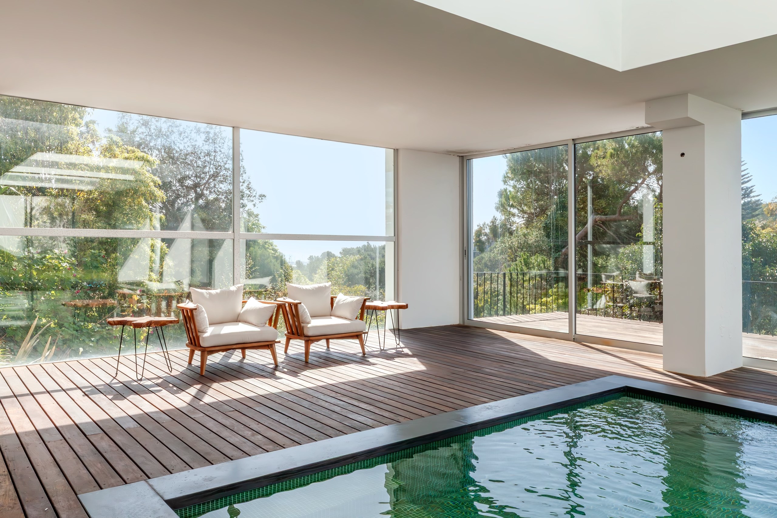 Modern lounge with indoor pool and garden views