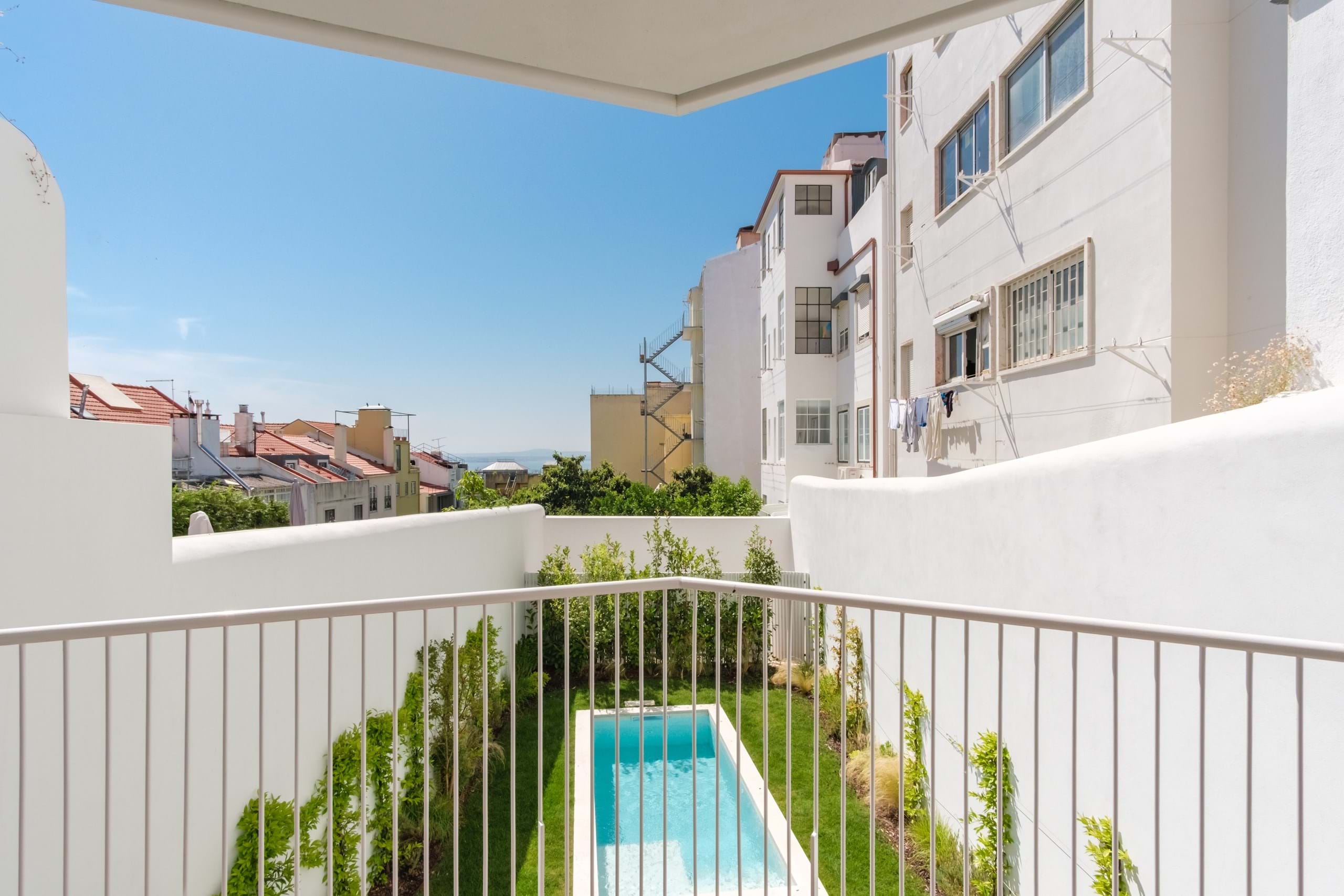 Balcony view over courtyard pool and white buildings