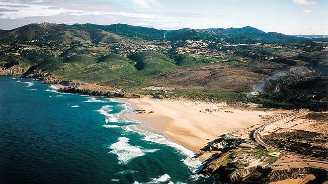 Aerial view of sandy beach and green hills