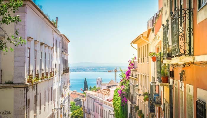 Sunny coastal street with colourful buildings and sea view