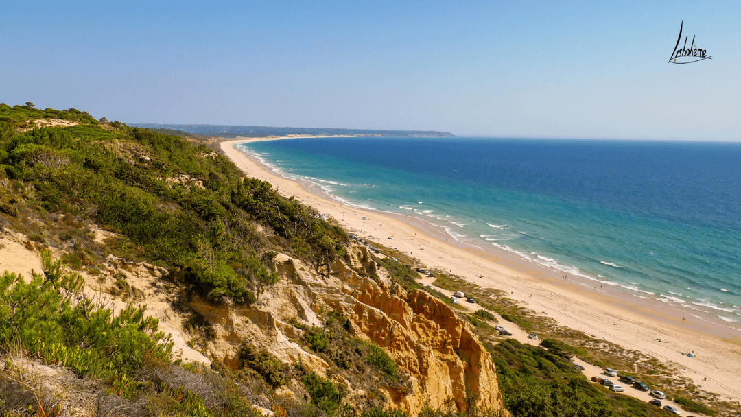 Cliffside view of long sandy beach and turquoise sea