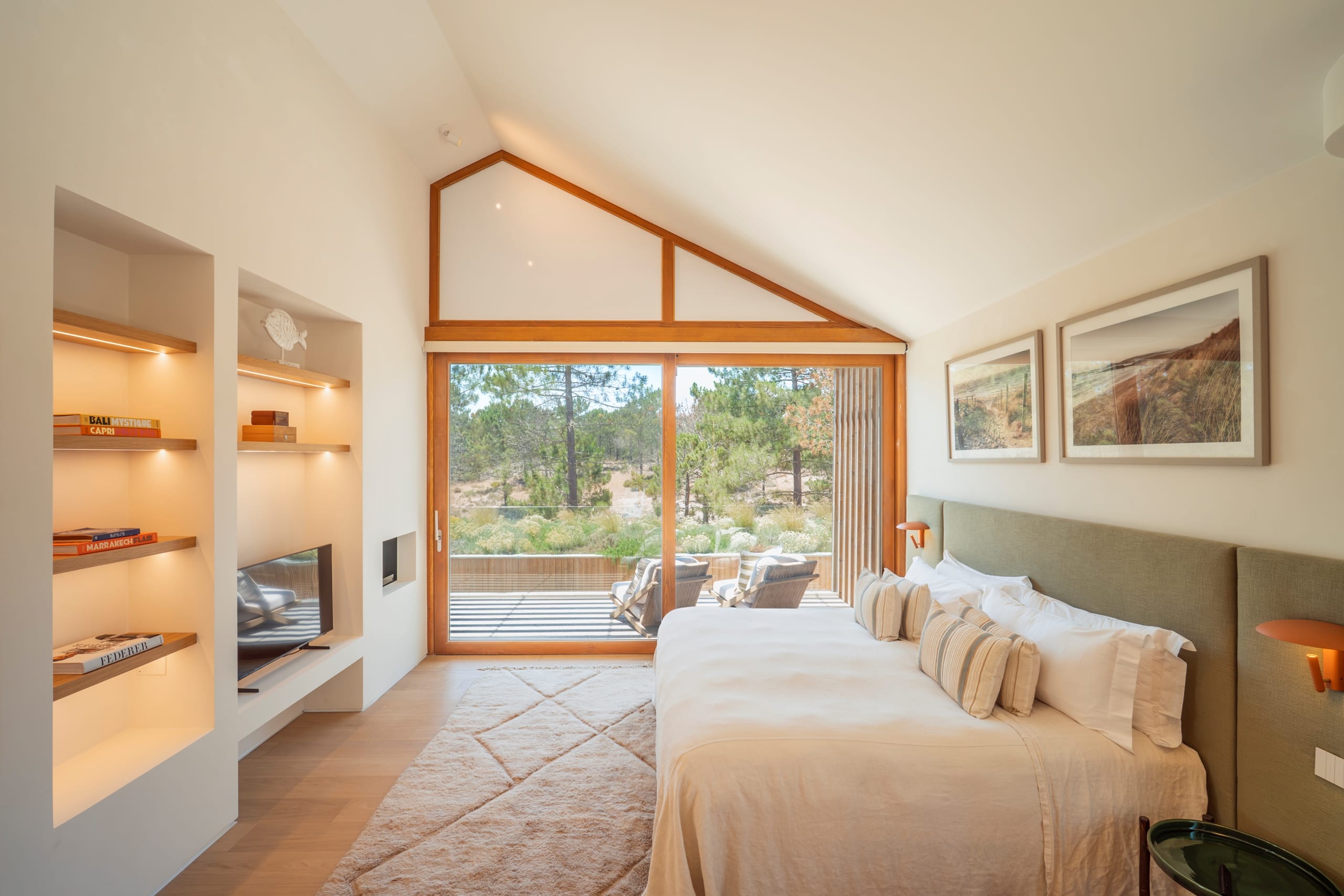 Modern bedroom with balcony overlooking woodland