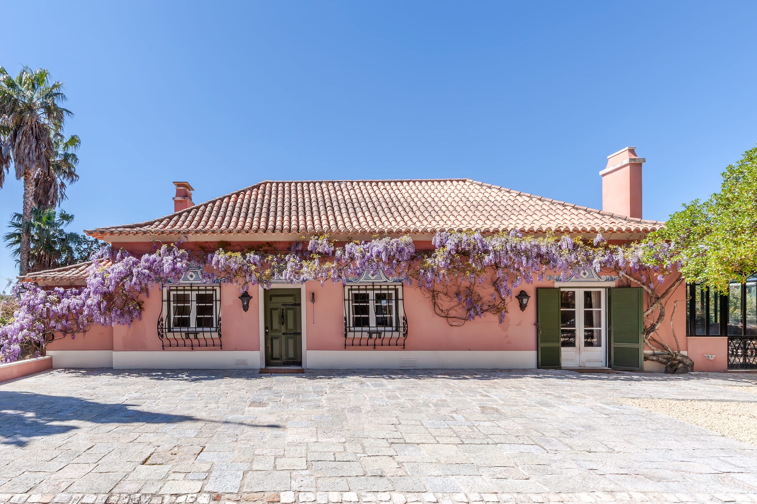Pink villa with wisteria and terracotta roof