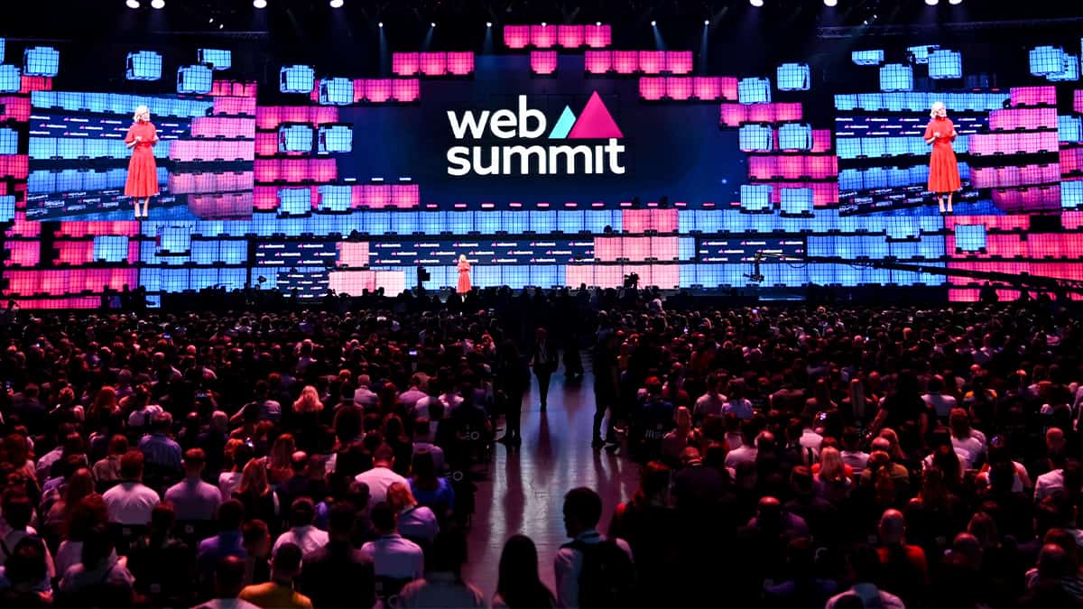 Speaker addresses audience on brightly lit Web Summit stage